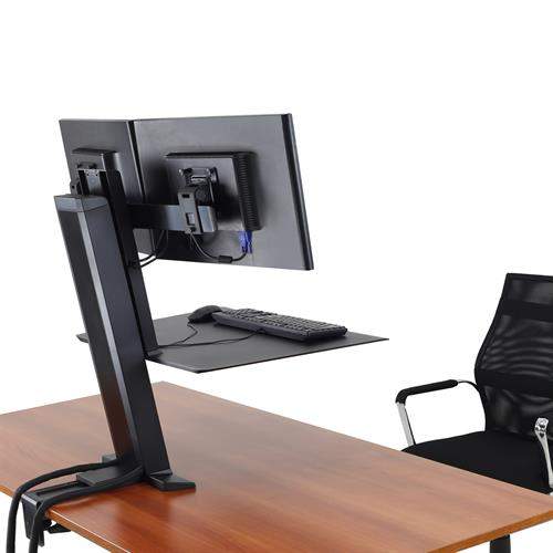 Back view of a keyboard and monitor stand sitting on a brown desk