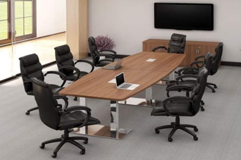 Medium sized brown conference table with a laptop on it